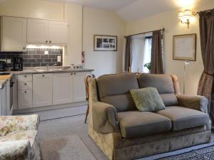 a living room with a couch and a kitchen at The Smithy in Brentor