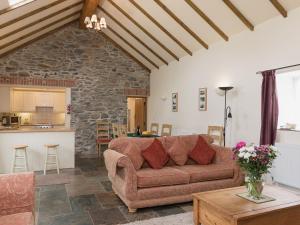 a living room with a couch and a kitchen at Yr Hen Stabl in Tregaron