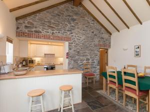 a kitchen with a counter and chairs in a room at Yr Hen Stabl in Tregaron