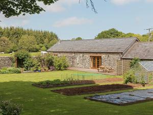 a garden in front of a stone building at Yr Hen Stabl in Tregaron