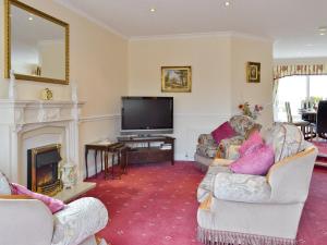 a living room with two couches and a television at Meadowcroft in Llanllwchaiarn