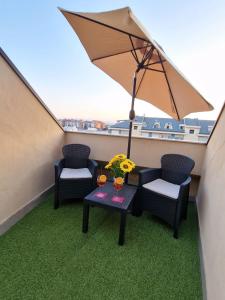 un balcone con due sedie, un tavolo e un ombrellone di A Casa Letizia Foggia a Foggia