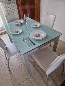 un tavolo blu con piatti e bicchieri da vino sopra di A Casa Letizia Foggia a Foggia
