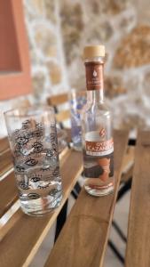 a bottle of water and a glass on a wooden table at G&A Rooms Marmari in Marmari