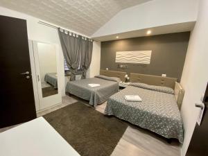 1 dormitorio con 2 camas y espejo en Guest House Minas, en Milán