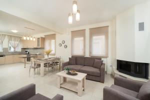 a living room with a couch and a table at Nik-Ntin Villa Deluxe in Prinos