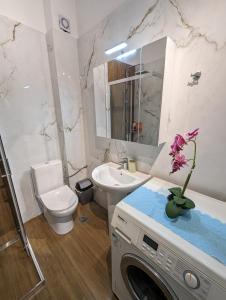 a bathroom with a toilet sink and a washing machine at Kouriton apartment is an ideal place to relax in Gouves