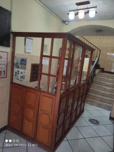 a large wooden cabinet with glass doors in a building at Hostal puerta del sol in Quito