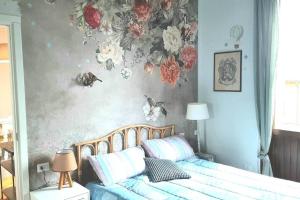 a bedroom with a bed with flowers on the wall at Interno 15 Diario di viaggio in Vigevano
