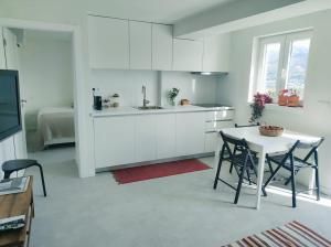 uma cozinha com armários brancos e uma mesa e cadeiras em Casa do Crasto em Soajo