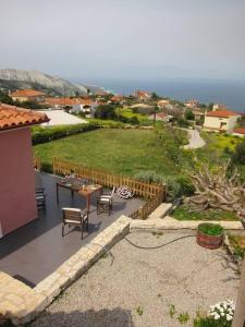 een patio met een tafel en stoelen en uitzicht bij Villa with spectacular view in Xylokastron