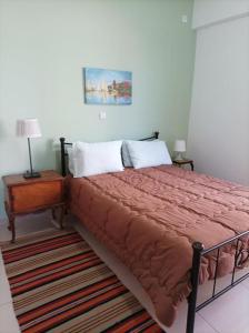 łóżko z czerwoną kołdrą w sypialni w obiekcie Villa with spectacular view w mieście Xylokastron