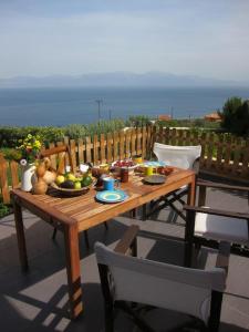 een houten tafel met groenten en fruit op een patio bij Villa with spectacular view in Xylokastron