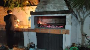 a man standing in front of a fireplace at La Pirca Rosada in San Fernando del Valle de Catamarca