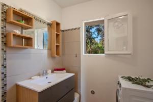 a bathroom with a sink and a window at MAISONS BORD DE MER- MARINE DE SORBO - Gîtes 3 épis in Pinarellu +128 photos