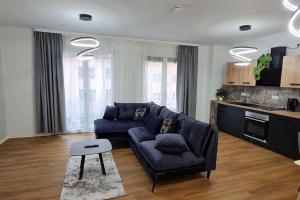 a living room with a blue couch and a kitchen at Luxus Wohnung im Stadtzentrum in Nuremberg