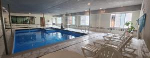 a large swimming pool in a building with chairs at Wingate By Wyndham Houston / Willowbrook in Houston