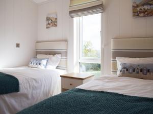 2 Betten in einem Zimmer mit Fenster in der Unterkunft Lodge 5 in Kinlet