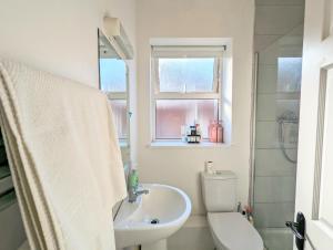 ein Bad mit einem Waschbecken, einem WC und einem Fenster in der Unterkunft Central Dublin Apartment Near Guinness & Heuston Station in Dublin