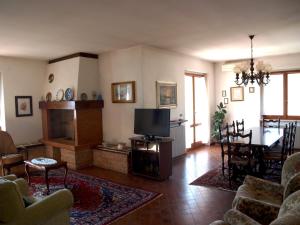 a living room with a television and a dining room at Casa di Licia in Volargne