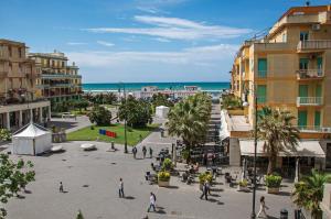 una città con persone che camminano per una piazza vicino alla spiaggia di RomeCookSea Guesthouse a Lido di Ostia