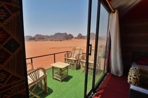 a room with a balcony with chairs and a table at Bedouin desert camp in Wadi Rum