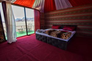 a bed in a room with a view of the ocean at Bedouin desert camp in Wadi Rum