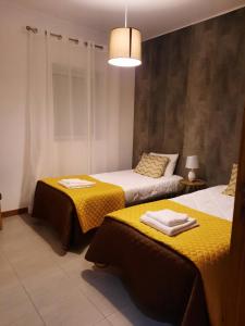 a bedroom with two beds with towels on them at Vila Nova House in Vila Nova