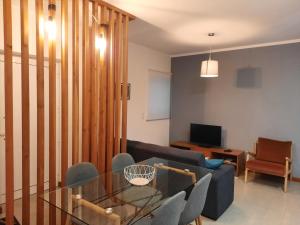 a living room with a glass table and chairs at Vila Nova House in Vila Nova