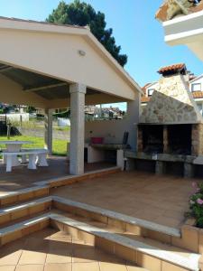 un patio con parrilla y horno de pizza en FINCA AMEIROS, en O Grove