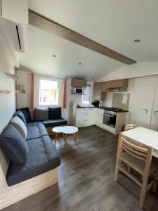 a living room with a couch and a table at Valras-Plage, les sables du midi ,mobil home in Sérignan