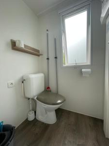 a bathroom with a toilet and a window at Valras-Plage, les sables du midi ,mobil home in Sérignan