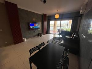 ein Wohnzimmer mit einem Tisch und Stühlen sowie einem TV in der Unterkunft شالهيات درة العروس in Durrat Al-Arus