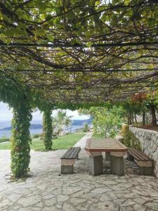 a picnic table and benches in a park with the ocean at Lux Villa Provence in Budva