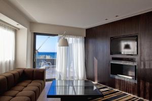 a living room with a couch and a tv at Aqua Blu Boutique Hotel & Spa, Adults Only- Small Luxury Hotels of the World in Kos