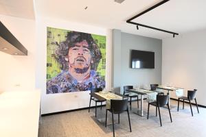 une salle à manger avec des tables et une grande peinture murale dans l'établissement HOTEL MOSAICO, à Matera