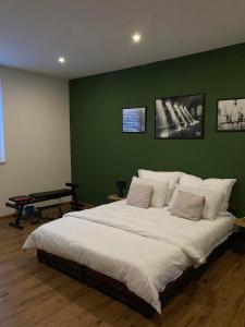 um quarto com uma cama grande e uma parede verde em Dovolenkový dom eLAra em Smizany