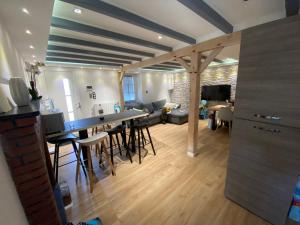 cocina y sala de estar con bar y sillas en Agréable Maison avec jacuzzi en Maisdon-sur-Sèvre