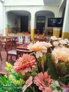 a bunch of flowers on a table in a restaurant at Hostal puerta del sol in Quito