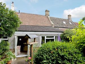 uma pequena casa com uma janela e um telhado em Rose Cottage em Cold Ashton