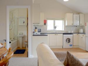 a kitchen with white cabinets and a washing machine at Lodge 2 in Kinlet