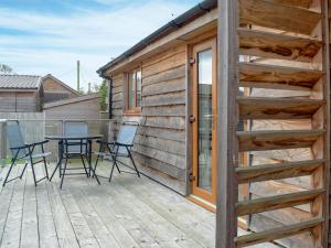 a wooden deck with a table and chairs on it at Lodge 2 in Kinlet