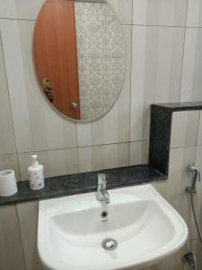 a white sink in a bathroom with a mirror at Royal Suites - 3 BHK - Neo in Pune