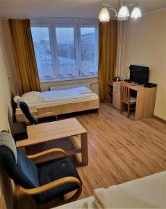 a room with a bed and a desk and a television at HOMER Bydgoszcz Ośrodek Rehabilitacji i Szkolenia PZN in Bydgoszcz