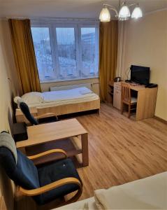 a room with a bed and a desk and a television at HOMER Bydgoszcz in Bydgoszcz