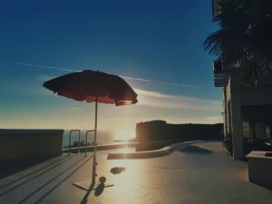 a umbrella sitting on a deck with the sun setting at Lux Villa Provence in Budva +61 photos