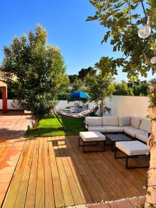 a patio with a couch and tables and a hammock at Catalunya Casas Blissful Costa Dorada Escape with private pool in Bisbal del Penedès