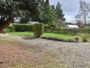 um jardim com uma cerca e um arbusto em Farm Cottage annex em Smallburgh