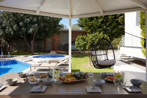 a table with bowls of fruit on it next to a pool at Kastellakia Executive Villa in Rethymno Town