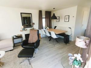 a living room with a dining room table and chairs at Sandy Feet Retreat in Petten